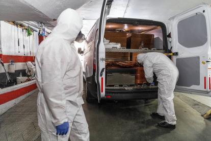 Dos trabajadores de la funeraria Santa Teresa de Segovia, en una imagen de archivo en plena primera ola de la pandemia durante el mes de abril. / ICAL