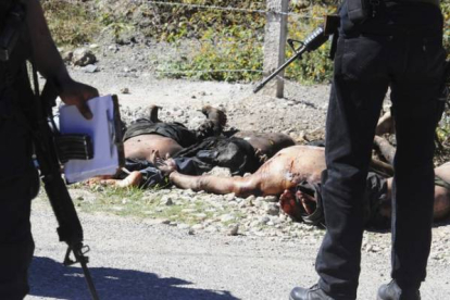 Policías mexicanos custodian los cadáveres aparecidos en Guerrero.-Foto: REUTERS