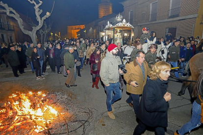 Vecinos y visitantes acompañan el carruaje que transporta a la Virgen de la Concepción, conducido por las mulas, junto a las tradicionales hogueras.-J.M. LOSTAU