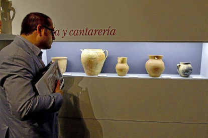 Un asistente observa la exposición ‘Entre pucheros’, de alfarería del siglo XVI.-J.M. Lostau