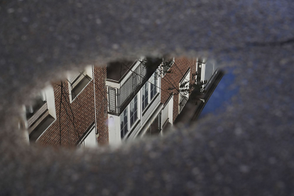 Reflejo de las viviendas de la calle Francisco del Rincón en un charco sobre el pavimento. J. M. LOSTAU