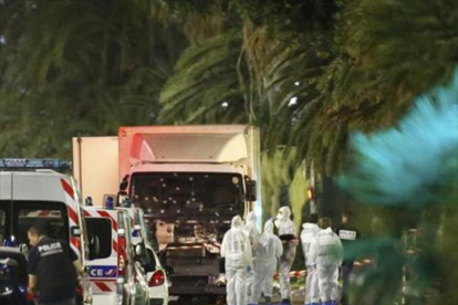 Un grupo de forenses examinan el camión del atentado de Niza.-REUTERS / ERIC GAILLARD