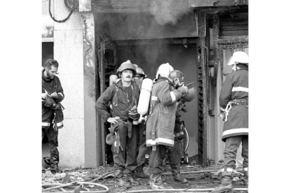 Un grupo de bomberos sale de la discoteca Siete Siete el día del incendio. -Horizontal