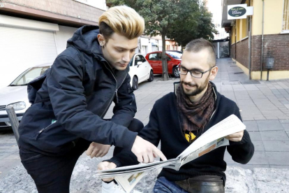 Álvaro y Pablo (sentado) mirando la sección de ofertas de trabajo del periódico.-J.M. LOSTAU
