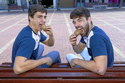 Álex Alonso y Juan Martínez se comen un kiwi, fruta típica de Nueva Zelanda.-J.M. LOSTAU
