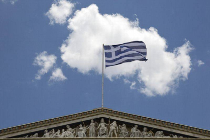 La bandera griega ondea en la Academia de Atenas.-Foto: AP