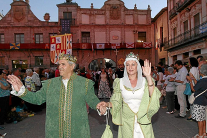 Dos actores ataviados al modo de los Reyes Católicos saludan en uno de los desfiles de una edición anterior.-J. M. LOSTAU