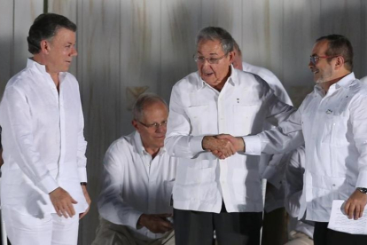 Raúl Castro, presidente de Cuba (centro) da la mano al comandante jefe de las FARC, Rodrigo Londoño, en presencia del presidente de Colombia, Juan Manuel Santos, en Cartagena de Indias, el 26 de septiembre.-AP / FERNANDO VERGARA