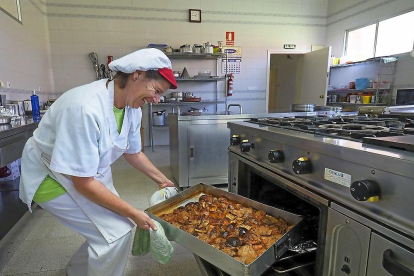 La cocinera Rebeca Mosquera saca del horno el pollo asado con limón y manzana.-MIGUEL ÁNGEL SANTOS (PHOTOGENIC)