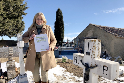 La historiadora y escritora Mercedes Sanz, con su libro, en el cementerio de la localidad segoviana de San Pedro de Gaíllos. ARGI COMUNICACIÓN