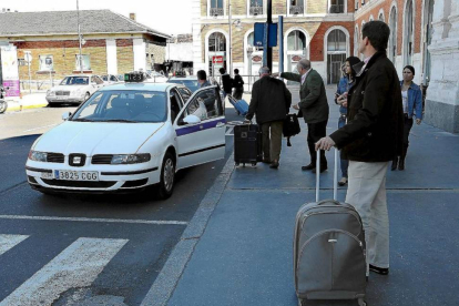 Varios viajeros esperan taxi en la parada de la estación de trenes-J.M.Lostau