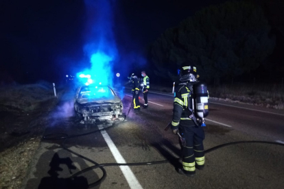 Los Bomberos de la Diputación apagan las últimas llamas del incendio del vehículo.- E. M.