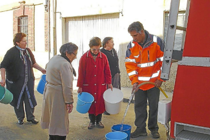 Vecinas de un pueblo de la provincia acuden a un camión cisterna para proveerse de agua potable, en una imagen de archivo.-EL MUNDO