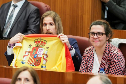 El portavoz de Podemos, Pablo Fernández, exhibe desde su escaño una bandera española durante la réplica de Herrera. .-M. A. SANTOS