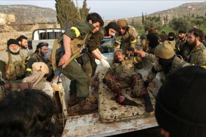 Miembros del Ejército Libre de Siria atienden a compañeros heridos en Rajo, este sábado 3 de marzo.-REUTERS / KHALIL ASHAWI