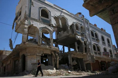 Un hombre camina ayer entre edificios destruidos de una ciudad siria-REUTERS / ALAA AL-FAQIR
