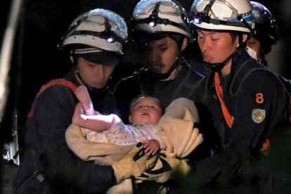 Un bebé de ocho meses rescatado por los trabajadores de emergencias este viernes en Japón.-HANDOUT