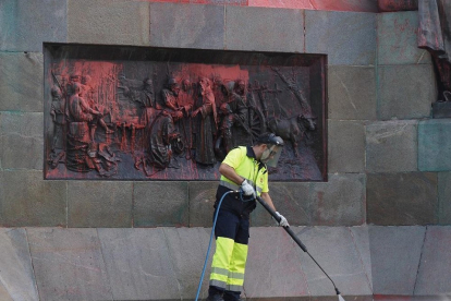 Empleado limpiando las pintadas del Monumento Colón a primera hora de la mañana el pasado 12 de octubre.-PHOTOGENIC / MIGUEL ÁNGEL SANTOS