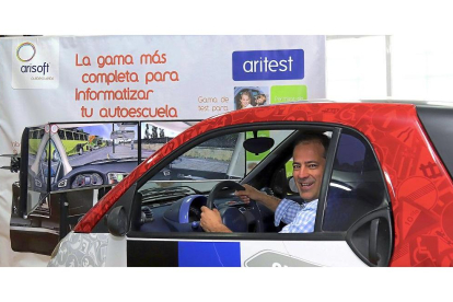 Carlos Arias posa en uno de los vehículos que sirve de simulador para sacarse el carné de conducir.-J. L. C.