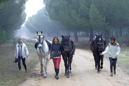 Una de las responsables de la ruta a caballo junto con dos participantes mientras realizan el itinerario con los caballos en la localidad de Simancas.-J.M. LOSTAU