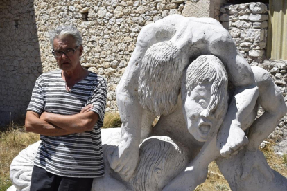 Luciano Santos, junto a su escultura de piedra El Parió, en su taller de Olombrada.-ARGICOMUNICACIÓN