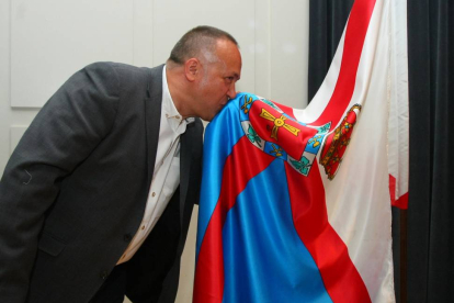 El nuevo presidente del Consejo Comarcal del Bierzo, el socialista Gerardo Álvarez Courel, besa la bandera del Bierzo al finalizar el pleno de constitución-ICAL