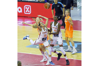 Anna Cruz supera la defensa de una jugadora holandesa ante la mirada de Astou Ndour.-J. M. LOSTAU