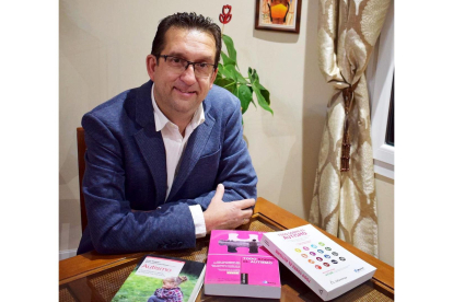 El profesor de la UBU José Luis Cuesta muestra algunos libros sobre autismo.-EL MUNDO