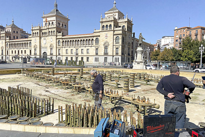 Dos operarios inspeccionan el estado de las viejas tuberías en la fuente de la Plaza de Zorrilla. J.M. LOSTAU