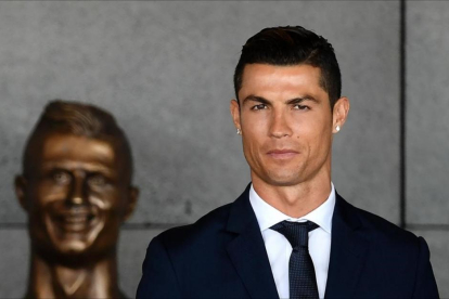 Cristiano Ronaldo en Madeira, junto al busto que le realizaron en su país.-AFP / FRANCISCO LEONG
