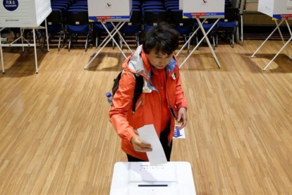 Una mujer deposita su voto en las elecciones de Corea del Sur.-KIM KYUNG-HOON / REUTERS