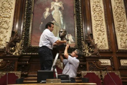 Operarios del Ayuntamiento de Barcelona retiran el busto del rey Juan Carlos del salón de plenos municipal antes de guardarlo en una caja de cartón.-Foto:   DANNY CAMINAL / CARLA FAJARDO