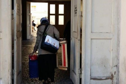Una refugiada entra con sus pertenencias en el centro de Wilmersdorfer.-ROSA MASSAGUÉ