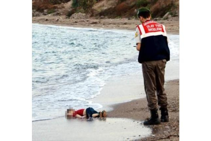 El niño sirio Aylan Kurdi, ante un guardacostas en la playa de Turquía a la que llegó su cadáver.-REUTERS / NILUFER DEMIR