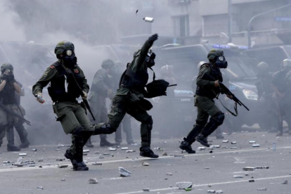 Policías lanzan botes de gas lacrimógeno contra los manifestantes que les lanzaron piedras y latas en las inmediaciones del Congreso, en Buenos Aires, el 14 de diciembre.-AP