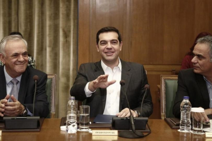 Tsipras (centro) gesticula junto al viceprimer ministro Yiannis Dragasakis (izq) y el ministro de Interior, Panagiotis Skurletis, en el consejo de ministros celebrado en el Parlamento, en Atenas, este domingo.-EFE / YANNIS KOLESIDIS