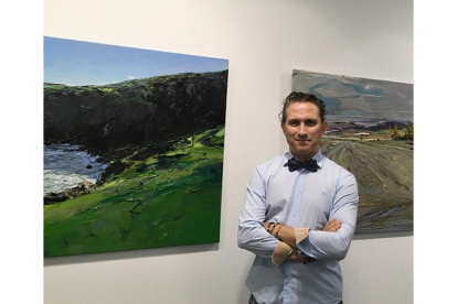 Isidoro Moreno junto a dos de los paisajes que exhibe en la Galería Espacio 36, en Zamora.-EL MUNDO
