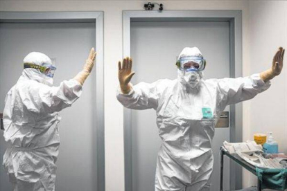Sanitarios de Valencia reciben indicaciones sobre el modo de colocarse los trajes para tratar el ébola.-Foto: MIGUEL LORENZO