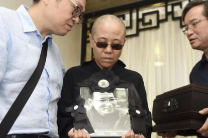 Liu Xia, esposa del premio Nobel de la Paz fallecido Liu Xiaobo, muestra una foto de su marido en día del funeral.-AP