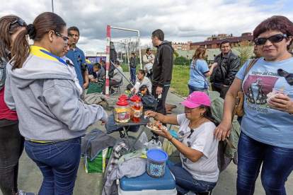 Una voluntaria reparte una ración de comida para recaudar fondos que ayuden al pueblo ecuatoriano.-M.A. SANTOS