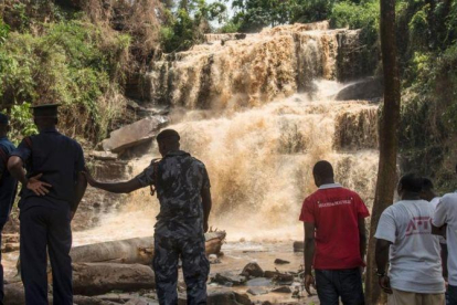 Policías y voluntarios frente a la cascada en la que un árbol mató a 18 personas.-CRISTINA ALDEHUELA