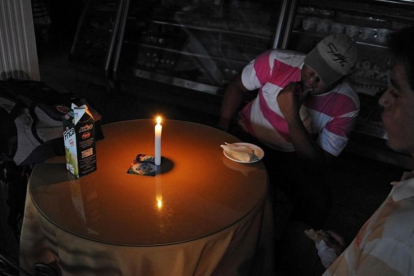 Hombres sentados en una panadería en San Cristóbal, a 600 kilómetros al oeste de Caracas, el 25 de abril.-AFP / GEORGE CASTELLANOS