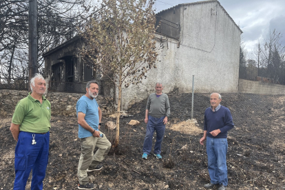 Ángel, Isidro, Alberto y Olegario, junto a una de las casas quemadas en Otero de Bodas.- E. M.