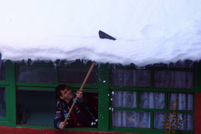Un vecino de la localidad berciana de Colinas del Campo de Martín Moro Toledano (León), retira la nieve acumulada en su tejado durante los últimos días-Ical
