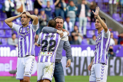 El entrenador Sergio se abraza a Nacho mientras Olivas (izquierda) y Plano saludan a la afición tras la victoria.-J.M. LOSTAU