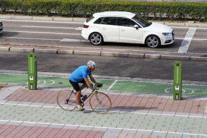Un ciclista pasa por delante de uno de los puntos de recarga eléctrica de Valladolid. / PHOTOGENIC / MIGUEL ÁNGEL SANTOS