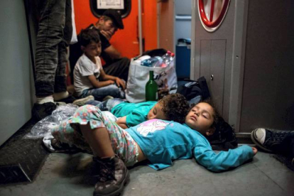 AFP / VLADIMIR SIMICEK 

Unos niños duermen en la estación de trenes de Keleti mientras esperan poder viajar a Alemania desde Hungría.