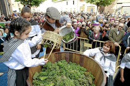 Tres niños arrojan uvas a un lagar en una anterior edición de la Fiesta de la Vendimia de Rueda.-J.M. LOSTAU