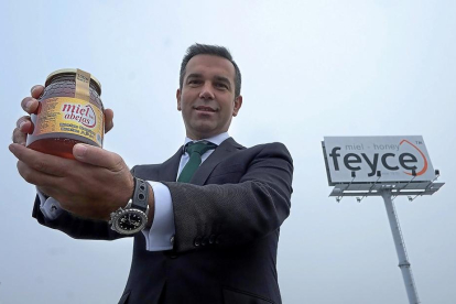 César Redondo sujeta un tarro de miel producido por Feyce.-ENRIQUE CARRASCAL