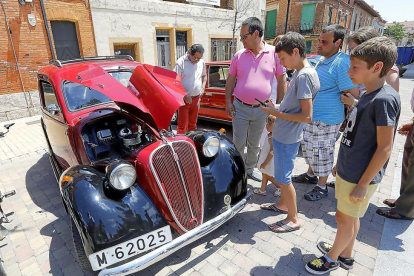 Viandantes contemplan en Cigales el premio al Coche más Antiguo, un Fiat 1100 del año 1936.-J.M. Lostau